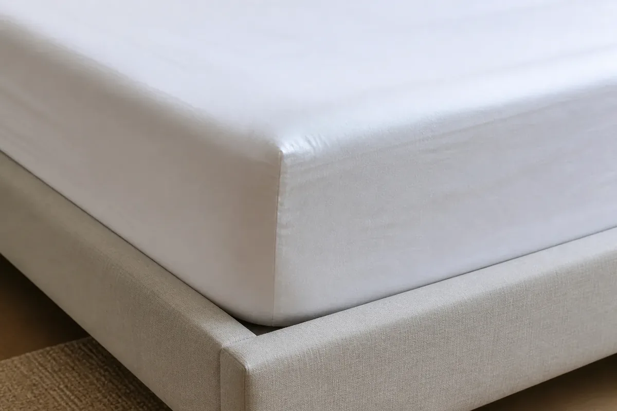 Close view of a fitted sheet pocket wrapped correctly under a mattress corner