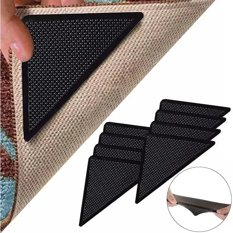 Black triangular reusable rug gripper pads shown under a rug corner