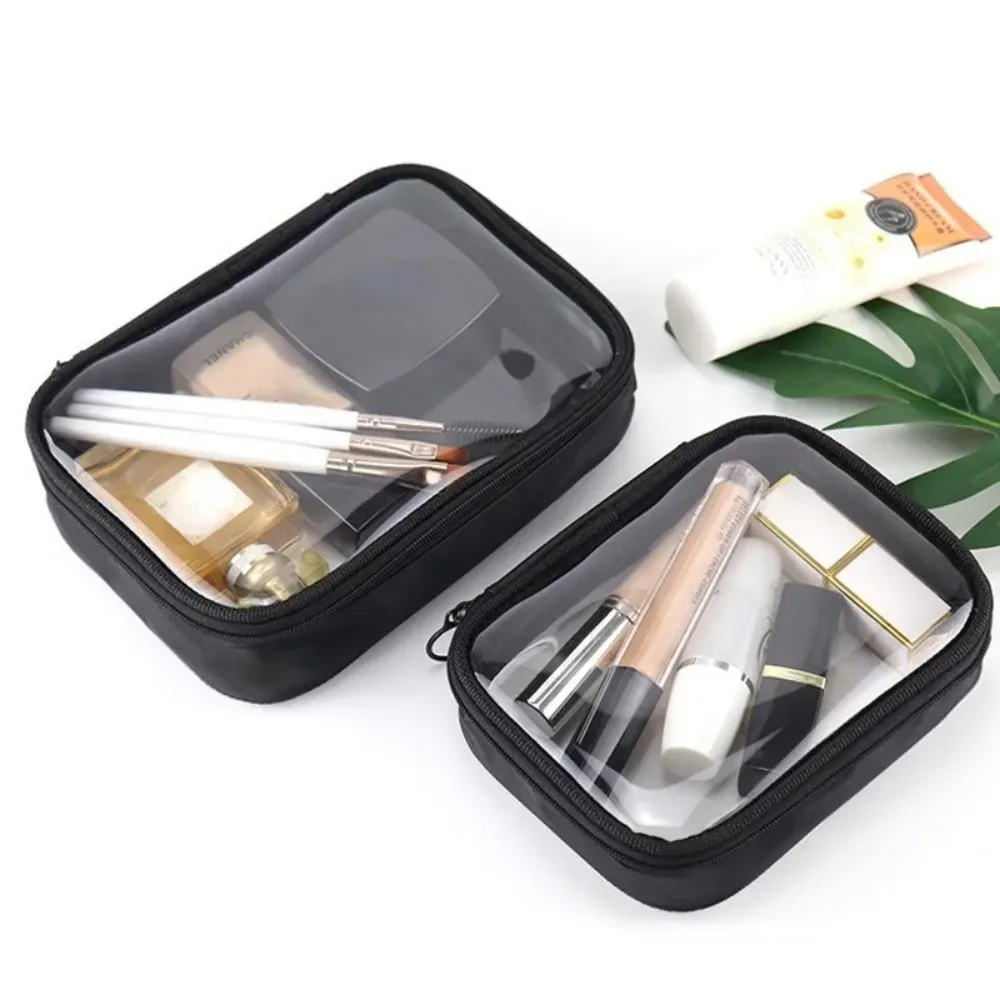 Two black transparent zip toiletry cases holding small cosmetic bottles and brushes